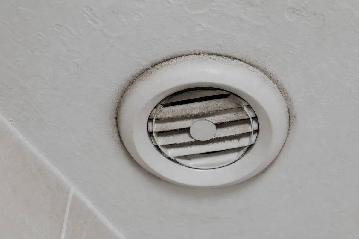 Bouche d&rsquo;extraction de ventilation encrassée au plafond d&rsquo;une salle de bains